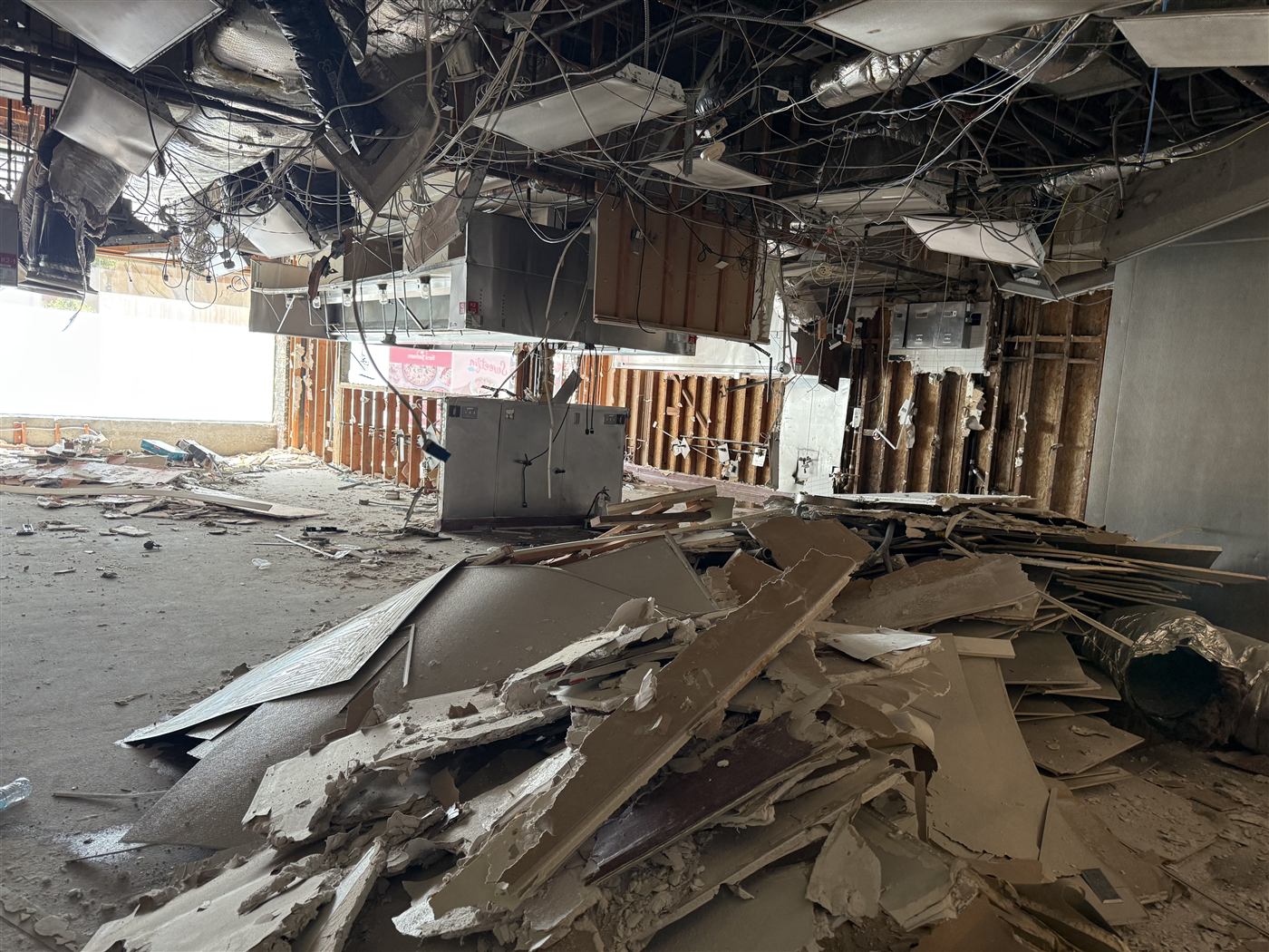 Gutted commercial kitchen interior with ceiling and equipment strip-out